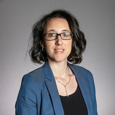 Chiara Giorio headshot wearing blue jacket and glasses